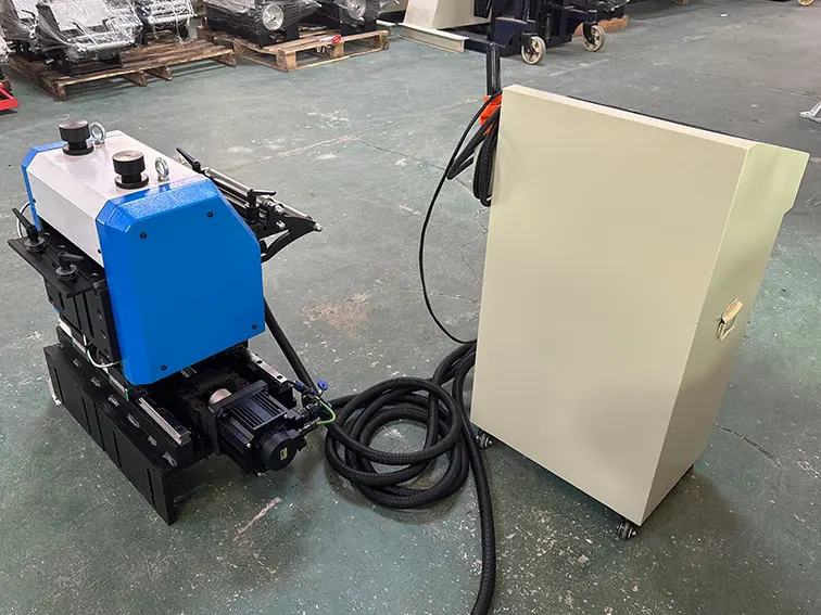 Industrial hydraulic power pack with a blue cover connected to a beige control cabinet on wheels in a warehouse setting.